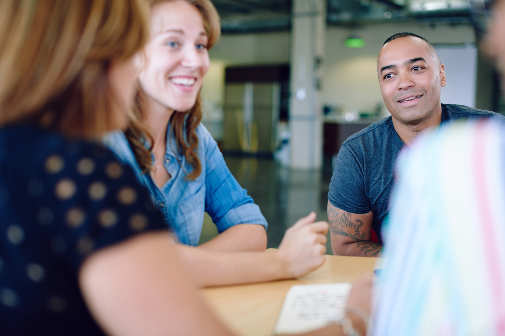 Unposed group of creative business people in an open concept office brainstorming their next project.-12